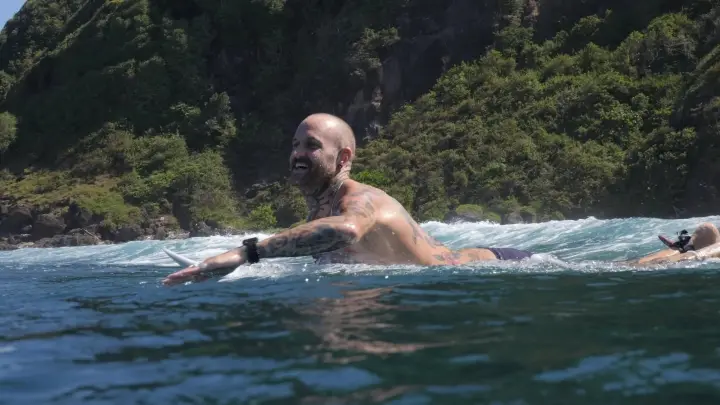 Island Ink founder paddling out to surf in Bali